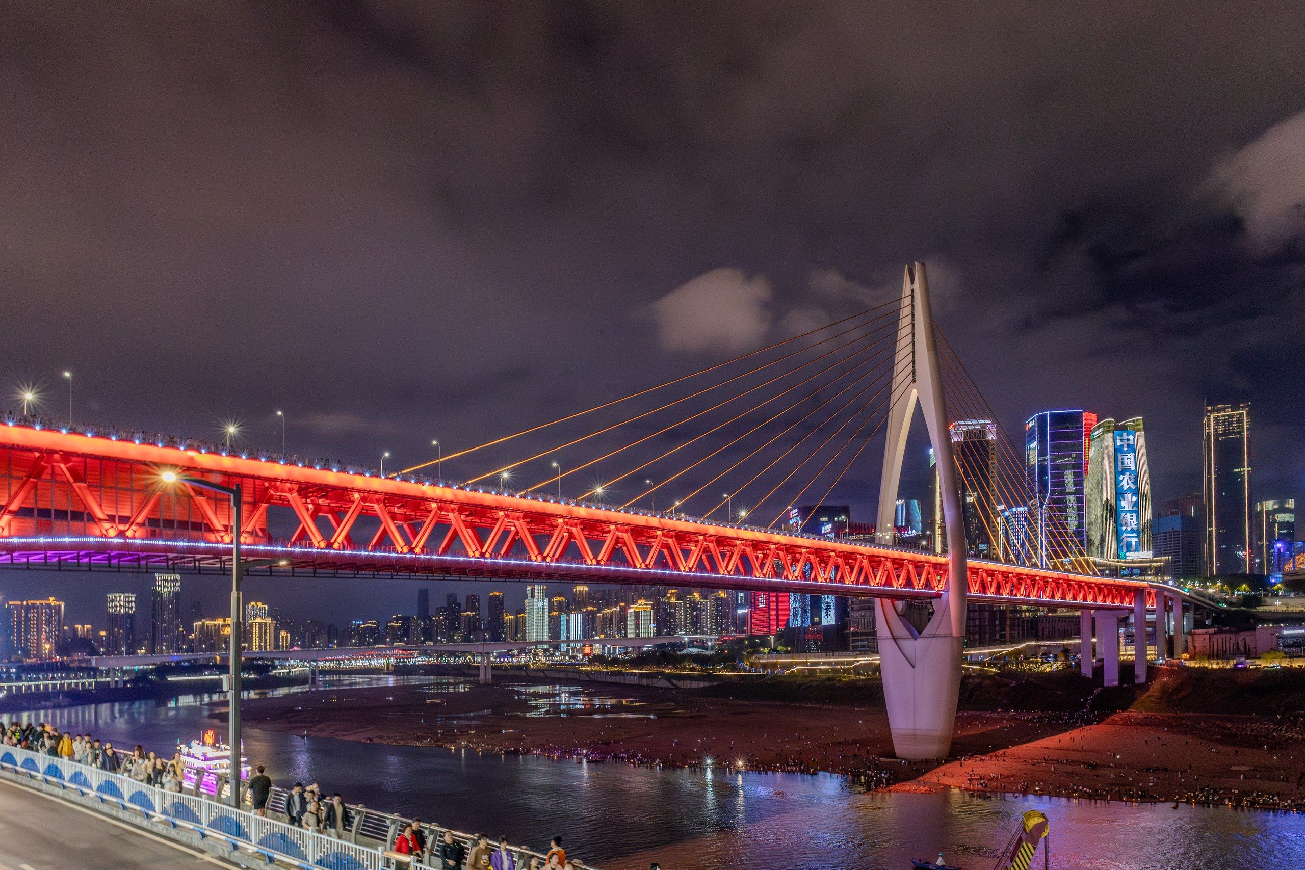 夜晚亮起红色灯光的重庆跨江大桥